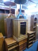 A PINE GLAZED HI-FI CABINET, two slim open bookcases, a painted circular table, etc (5)