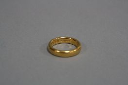 AN EARLY 20TH CENTURY 22CT GOLD WEDDING BAND, plain polish court shaped band measuring approximately
