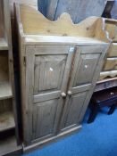 A SLIM PINE TWO DOOR BOOKCASE