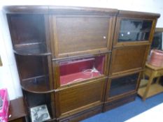 A DOUBLE OAK GLAZED SECTIONAL BOOKCASE, each section with lower drawer and a separate set of bowed