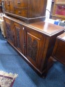AN EDWARDIAN CARVED WALNUT THREE DOOR SIDEBOARD