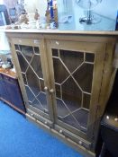 A PINE GLAZED TWO DOOR BOOKCASE, above two drawers, approximate size width 112cm x depth 33cm x