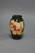 A SMALL MOORCROFT POTTERY VASE, Hibiscus pattern on green ground, impressed marks to base, height