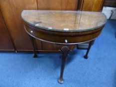 A WALNUT DEMI-LUNE FOLD OVER CARD TABLE (sd)