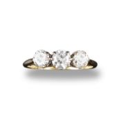 A diamond three stone ring, the three old circular cut diamonds are set in yellow gold. Size M 1/2.