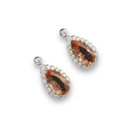 A pair of topaz and diamond drop earrings, the pear shaped topaz are set within a surround of