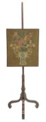 A George III mahogany pole firescreen, with a needlework panel of an urn of flowers, dated `1750`,