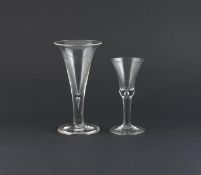 Two large wine glasses, one of drawn trumpet shape with everted rim, raised on a teardrop stem,