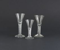 Three wine glasses, 2nd half 18th century, all with drawn trumpet bowls raised above thick