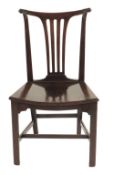 A George III mahogany hall chair, with a leaf wrapped scroll back and fan splat above a solid