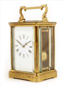 A carriage clock, white enamel dial, lever platform, striking and repeating on a gong, in a brass
