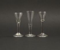 Three wine glasses, mid 18th century, two with drawn trumpet bowls raised on teardrop stems, the