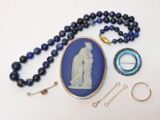 A gold plated Wedgwood oval plaque brooch, in cobalt blue porcelain with a raised figure of a