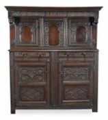 An oak press cupboard, late 17th/early 18th century, the moulded cornice above the acanthus carved