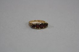 A LATE 20TH CENTURY 9CT GOLD GARNET AND DIAMOND HALF HOOP RING, approximate total diamond weight 0.