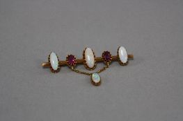 AN EARLY 20TH CENTURY OPAL AND GARNET BAR BROOCH, comprising of cabochon cut white opals and oval