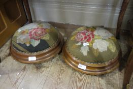 A pair of Victorian mahogany foot stools of circular outline with original floral needlework covers