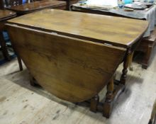 A good oak oval gateleg dining table on turned and square framing, to seat 8,