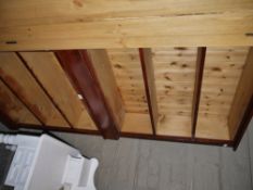 A pair of stained pine open bookshelves