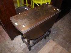 An early 20th century oak oval drop leaf supper table on baluster and square framing