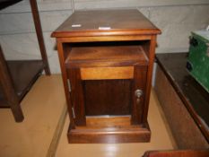 A modern hardwood bedside cabinet with open compartment and single door cupboard