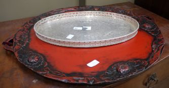 A silver plated gallery tray of oval outline together with a large red lacquered two handled tray