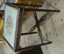 A mahogany table of Georgian style having a glazed surface with inset floral needlework panel on