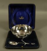 A silver bowl and spoon, with reeded and strapwork rim, initialled, in fitted case, Sheffield 1929,