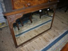 Waring and Gillows oak framed beveled wall mirror having an moulded cornice and grape vine carved