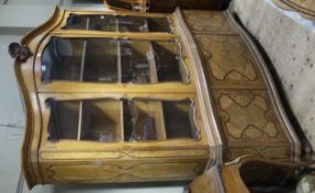 A Continental burr walnut and ebony inlaid serpentine fronted cabinet of arched outline having a