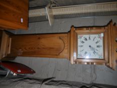 A reproduction pine longcase clock