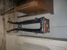 An oak and cast iron plant stand with animal mask and ring decoration to the legs