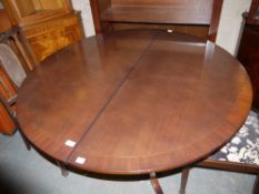 A mahogany circular extending dining table on quadruple base