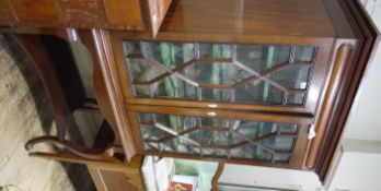 An early 20th century mahogany and glazed two door display cabinet having a moulded cornice above