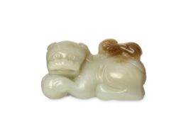 A CHINESE JADE ‘LION AND CUB’ CARVING. Seated with legs tucked beneath and the head turned to the